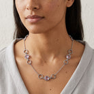 Woman in a light gray top wearing Light Amethyst Channel Crystal & Ring Chain Necklace