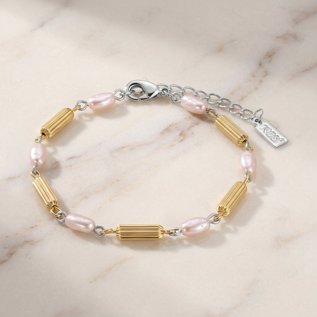 Faux Pearl Rice Bead & Cylindrical Gold Tone Bead Link Bracelet resting on white marble surface