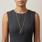 Woman in a dark sleeveless top wearing a purple stone Ol' Family Album Stone Locket Necklace 