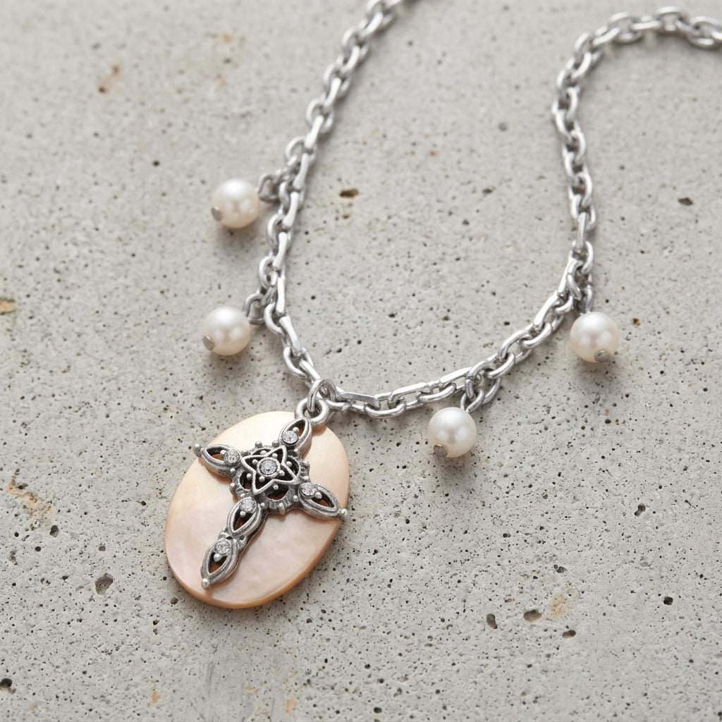 Faux Pearl Oval Disk Cross & Crystal Pendant Necklace resting on concrete surface