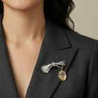 Woman wearing a black blazer with our Belle Epoch Ladies Crystal Hand Oval Disk Cross & Crystal Pin