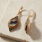 Tigers Eye Glass Stone Drop Earrings resting on limestone