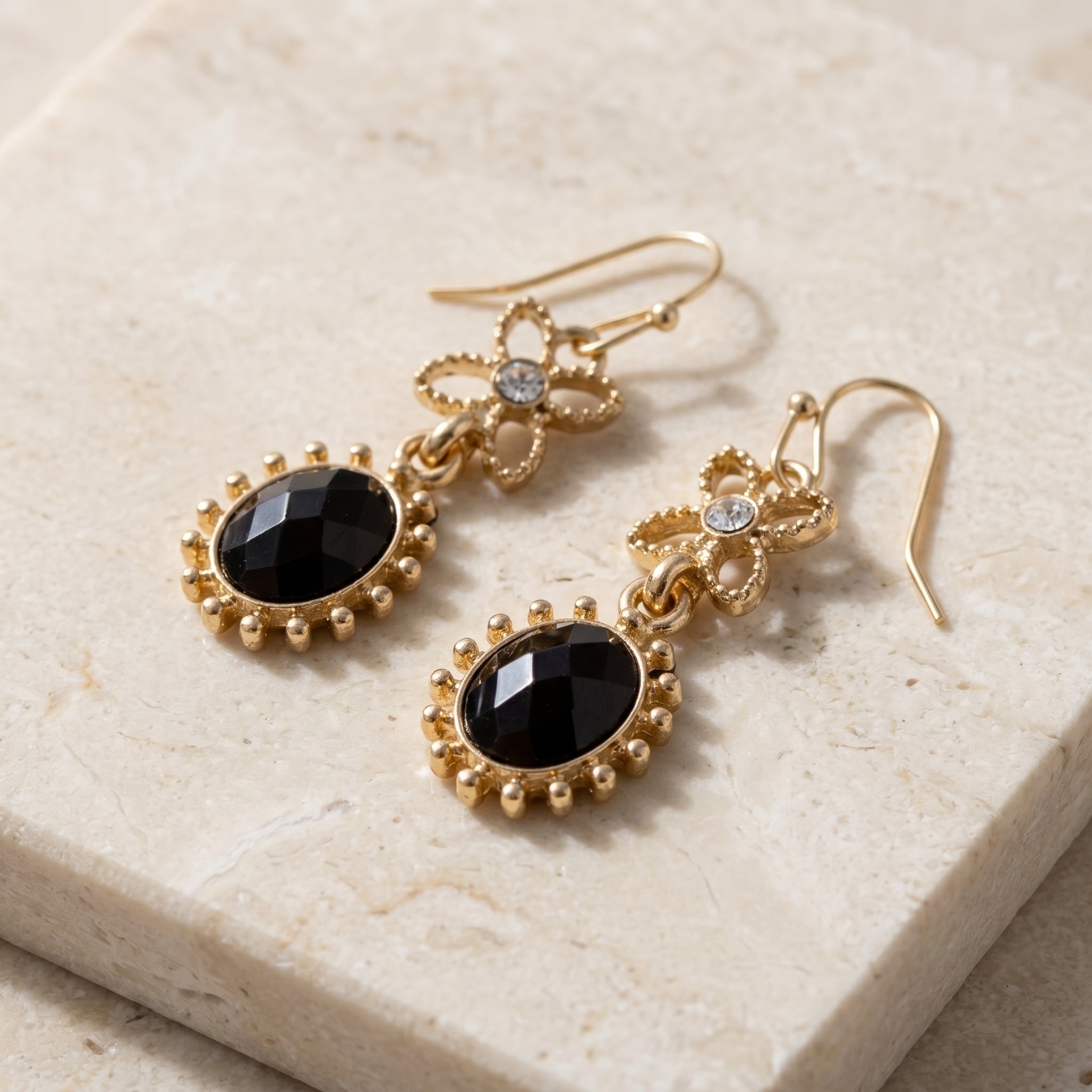 Black Sol Oval Stone Crystal Dangle Earrings on light stone