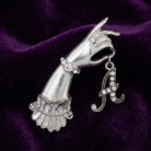 Belle Epoch Victorian Hand Model Crystal Initial Pin resting on dark purple fabric