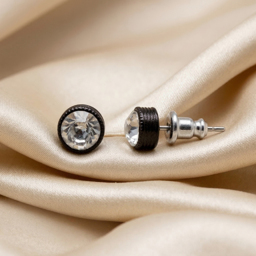 Pair of earrings with clear crystal on a beige satin background