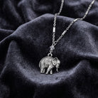 Pewter Elephant Drop Chain Pendant Necklace resting on dark fabric 