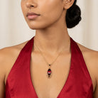 Woman in an elegant red dress wearing our Alluring Siam Red Filigree Pendant Necklace