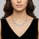 Woman wearing a sparkling vintage Austrian crystal necklace against a neutral background