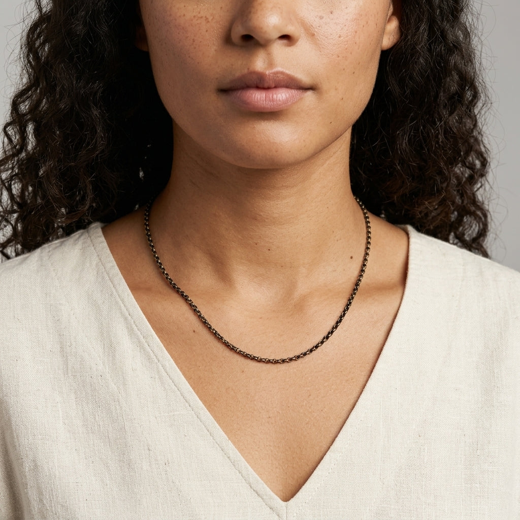 Eclipse Black And Gold Single Strand Cable Necklace 16" worn by a model with a white v-cut top