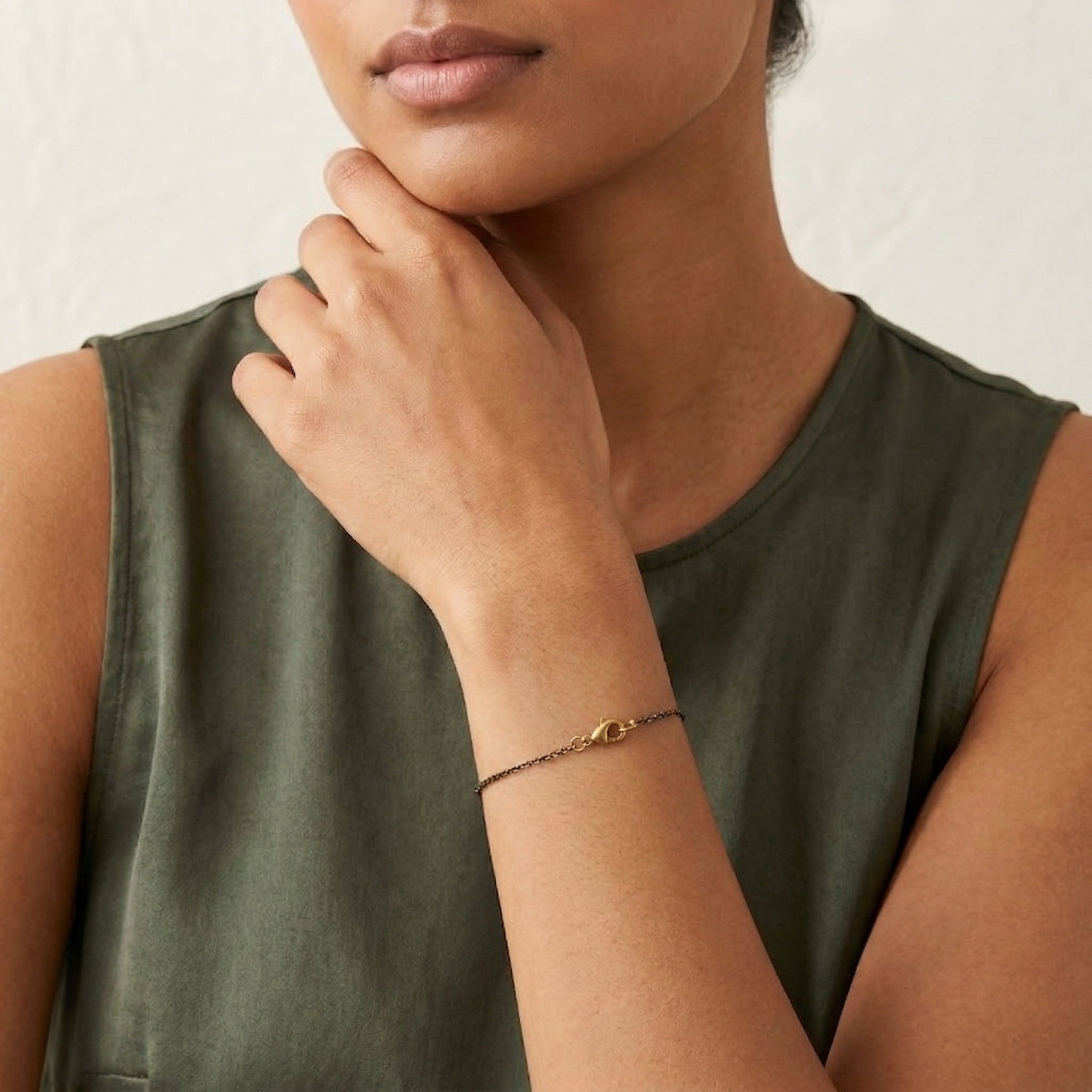 Woman in a sleeveless top wearing our Eclipse Black And Gold & Chain Bracelet