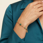 Woman wearing a teal shirt with a Faceted Green Crystal Beaded Chain Bracelet