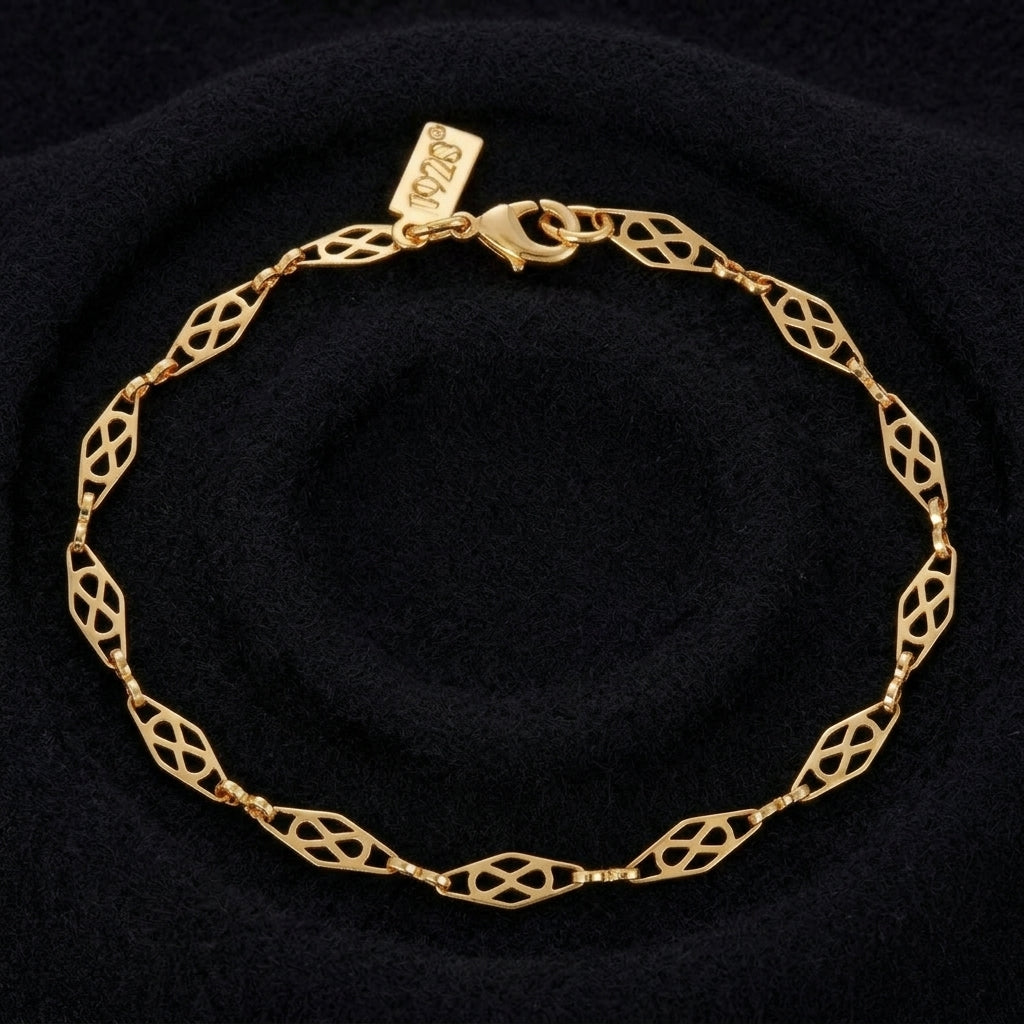 A gold link bracelet with an openwork geometric diamond pattern, displayed on a black textured background. 