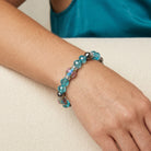 Woman wearing a Pink Flower and Blue Bead Crystal Stretch Bracelet on her wrist