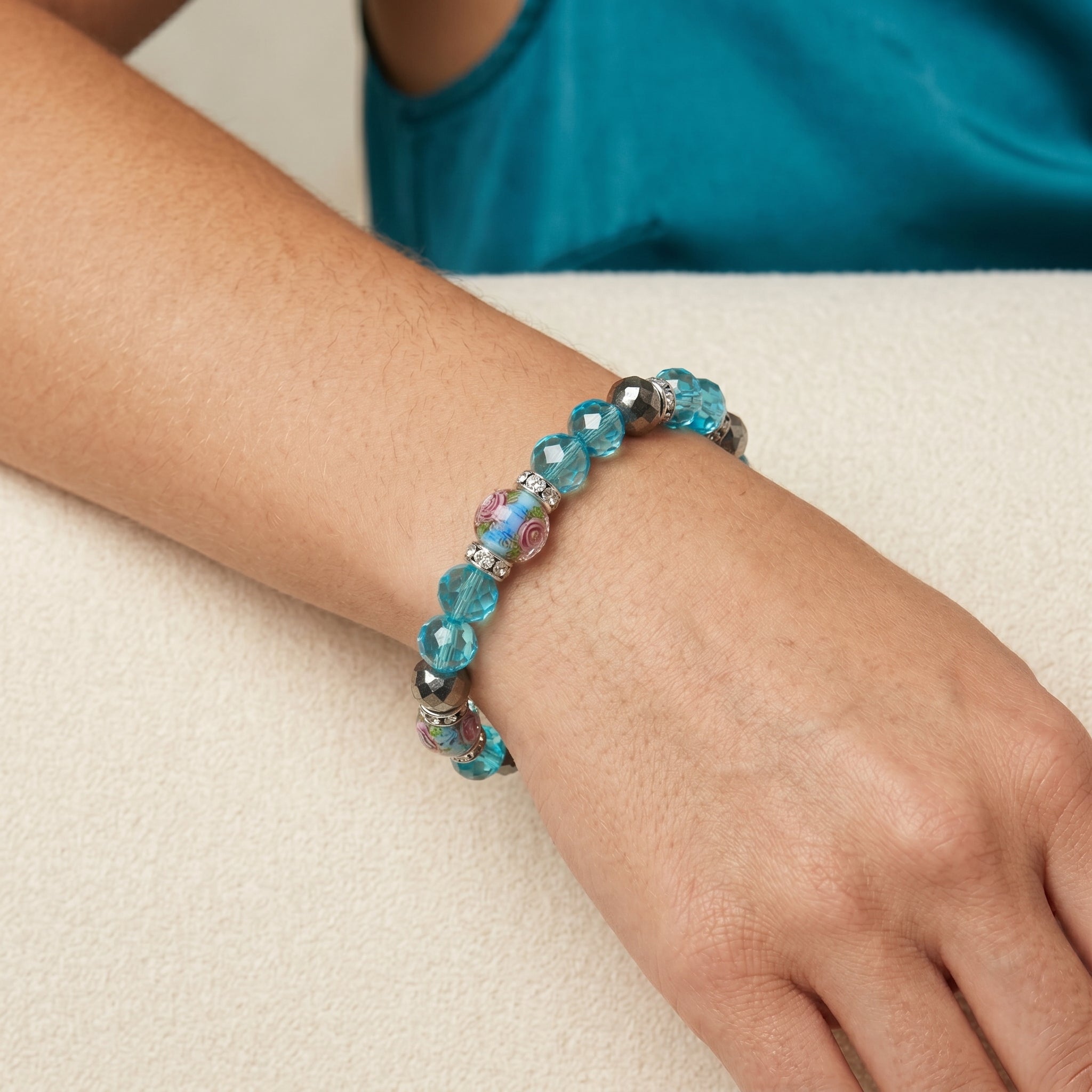 Woman wearing a Pink Flower and Blue Bead Crystal Stretch Bracelet on her wrist