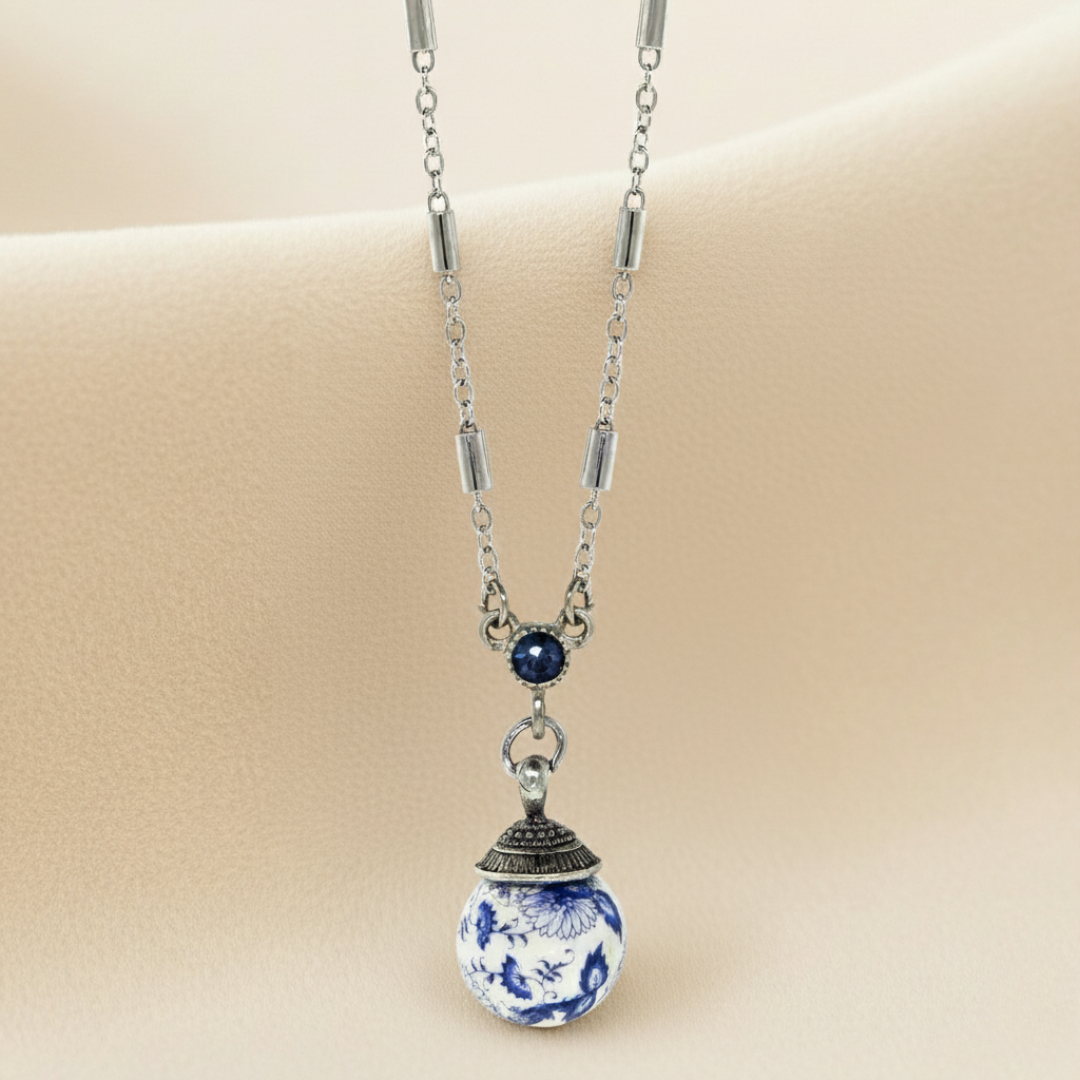 Necklace with a blue and white ceramic pendant on a beige background