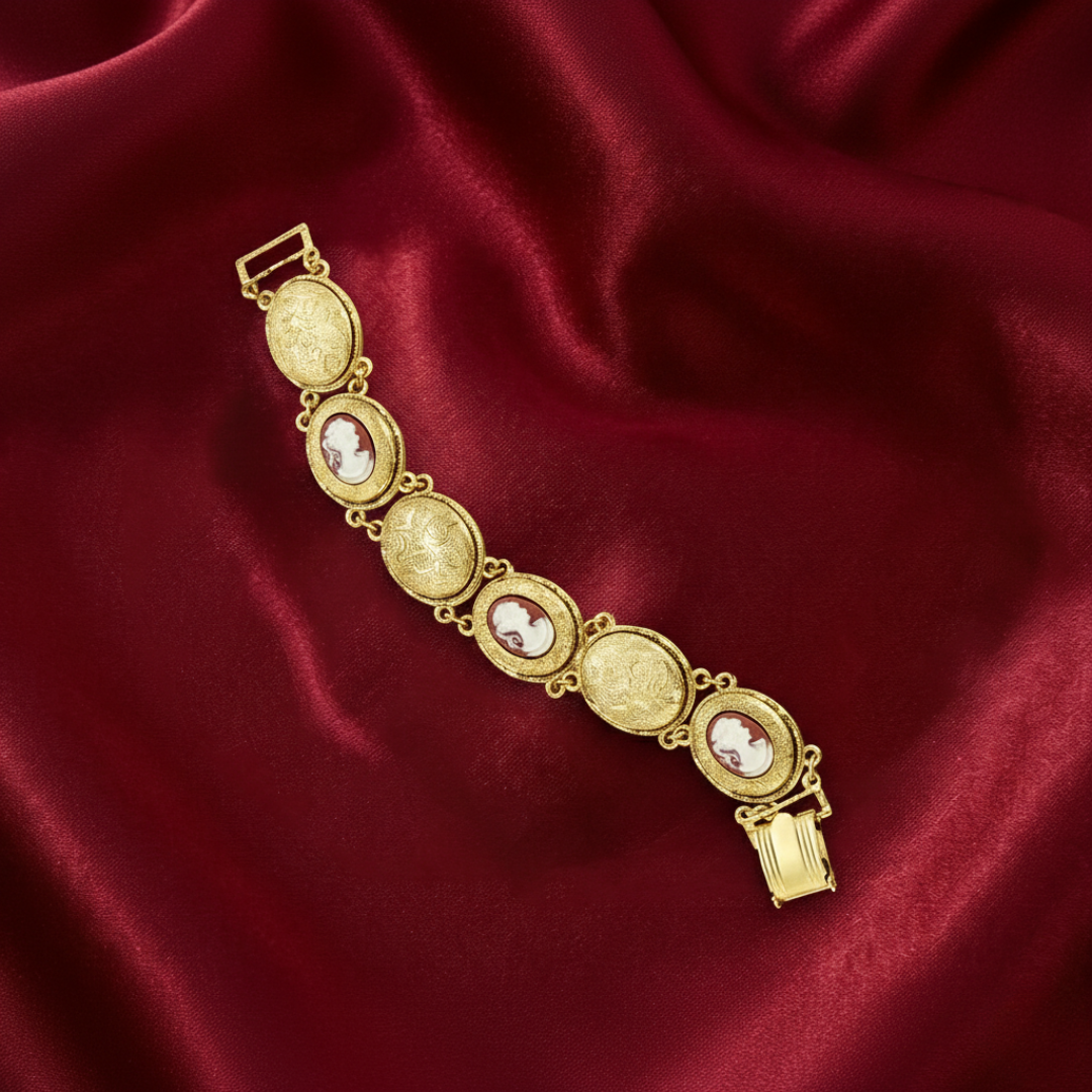 Gold bracelet with embedded cameo stones on a red fabric background