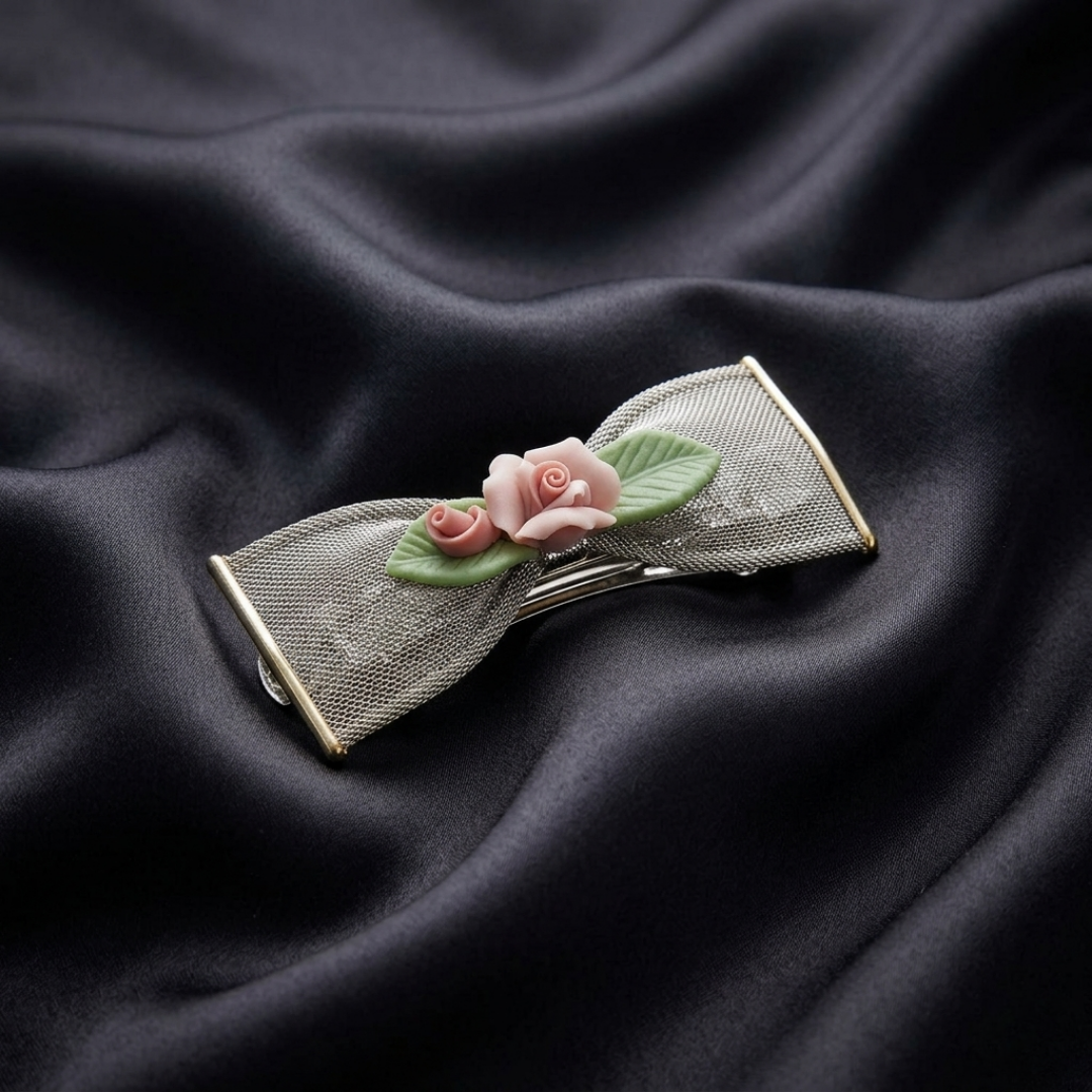 Decorative hair clip with floral porcelain rose design on a dark fabric background