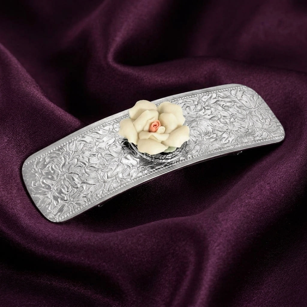 Decorative hair barrette with floral design on a purple fabric background