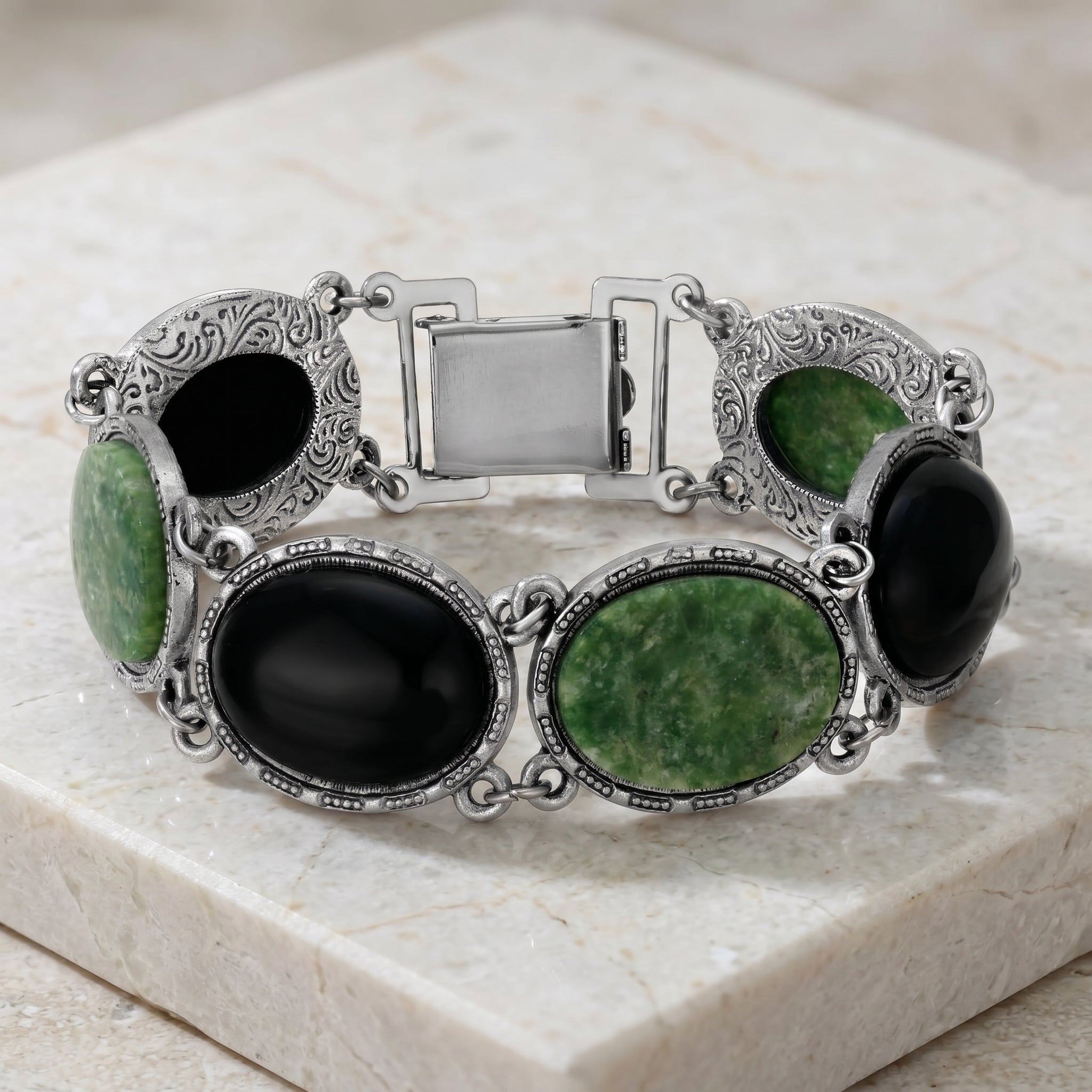 Silver tone Onyx & Jade Gemstone Link Bracelet resting on marble stone