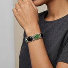 Woman in a gray shirt wearing a Silver tone Onyx & Jade Gemstone Link Bracelet on her wrist