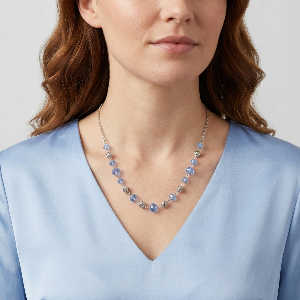 Woman in a blue top wearing Filigree Puff Bead Blue Crystal Chain Necklace