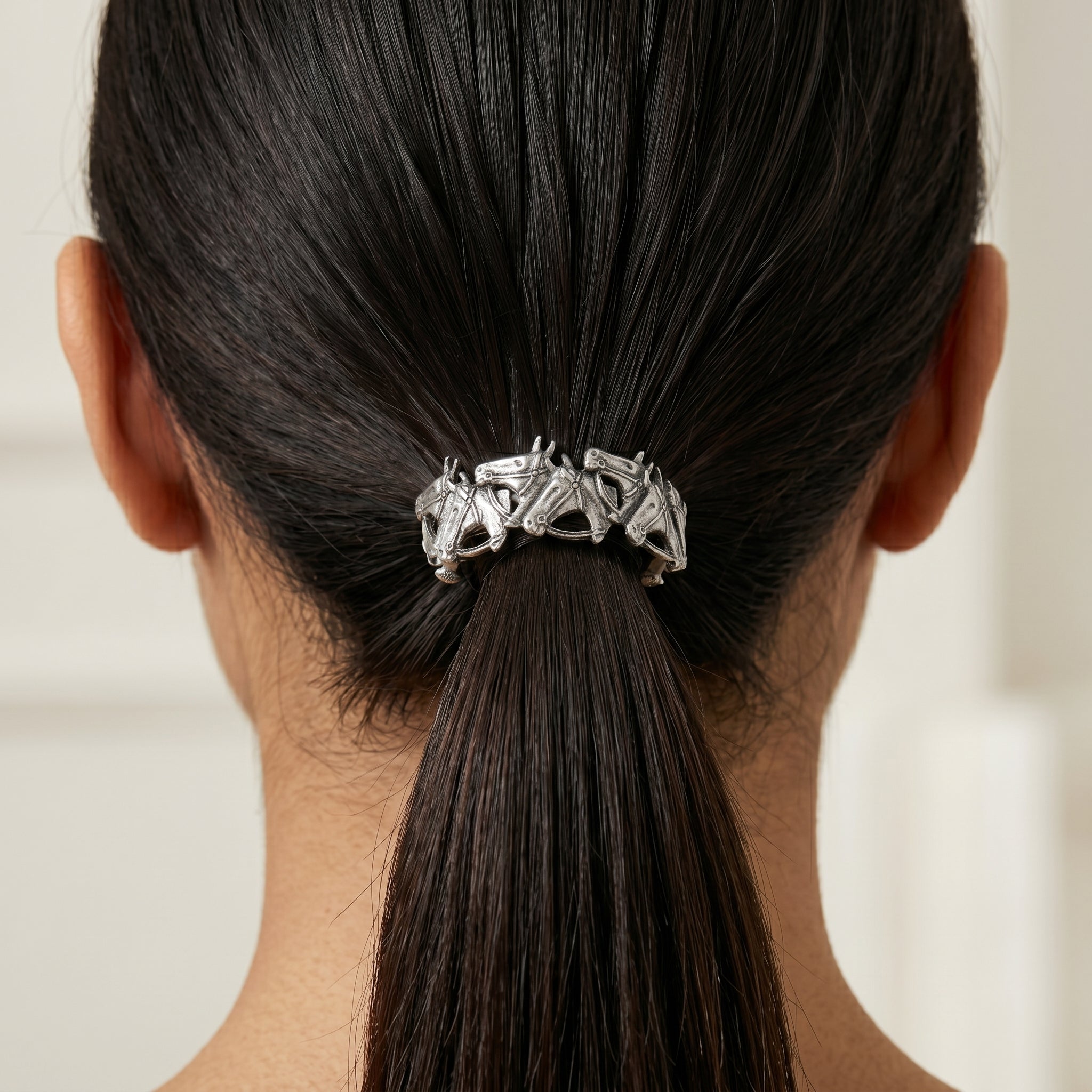 Woman wearing a pewter Racing Horses Ponytail Barrette in her dark hair