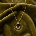 Classical Jet Black Baguette Stone Pendant necklace resting on yellowish green fabric