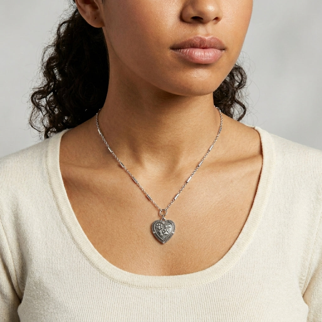 Heart Paws And Bones Pendant Necklace worn by a woman with dark curly hair and a white top
