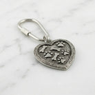 Bone And Paw Heart Carabiner Key Chain resting on marble stone