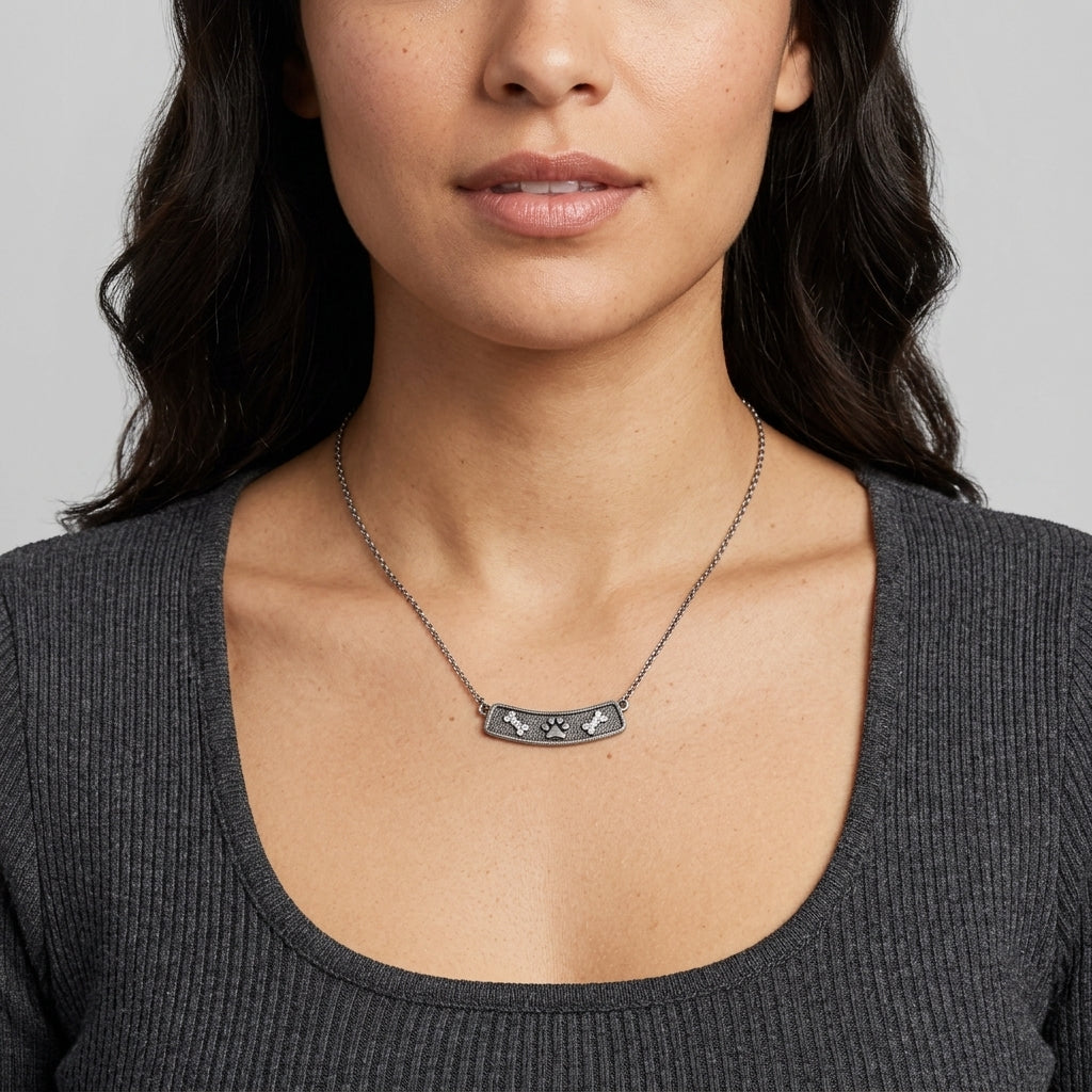 Woman wearing Crystal Bone And Paw Bar Pendant Necklace