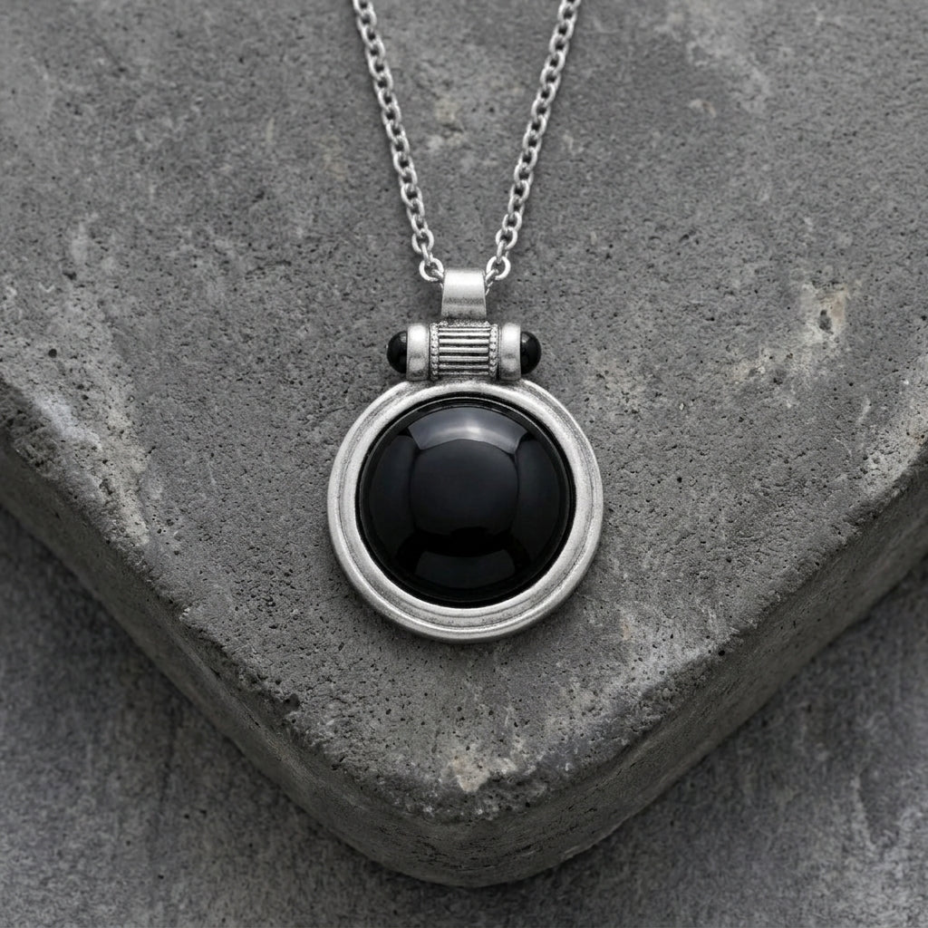 Onyx Cabochon Round Gemstone Pendant Necklace resting on concrete surface