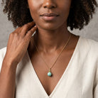 Woman in a white top posing and wearing our Turquoise Gemstone Round Beaded Drop Necklace