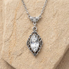 Navette Crystal Antiqued Drop Necklace resting on light stone surface