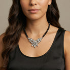 Woman in a black top wearing our Austrian Crystal Flower & Black Glass Beaded Necklace