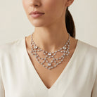 Woman wearing a sparkling vintage Austrian crystal swag drop necklace against a neutral background