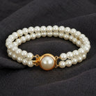 Double Strand 6mm Faux Pearl Bracelet resting on dark linen fabric