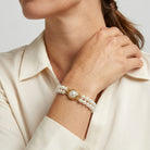 Woman wearing our Double Strand 6mm Faux Pearl Bracelet on her wrist with a white outfit