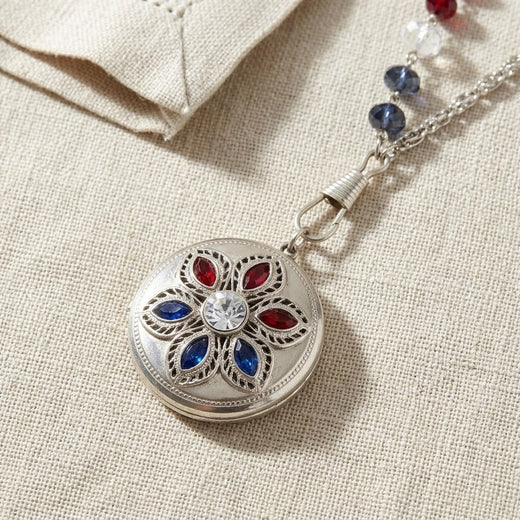 Silver tone Patriotic Red White and Blue Crystal Locket Necklaces on a beige fabric background