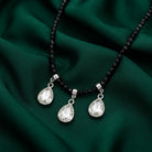 Black Bead Small Crystal Teardrop Necklace on a dark green fabric surface