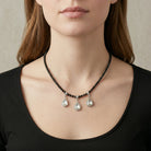 Woman in a black outfit wearing our Black Bead Small Crystal Teardrop Necklace 