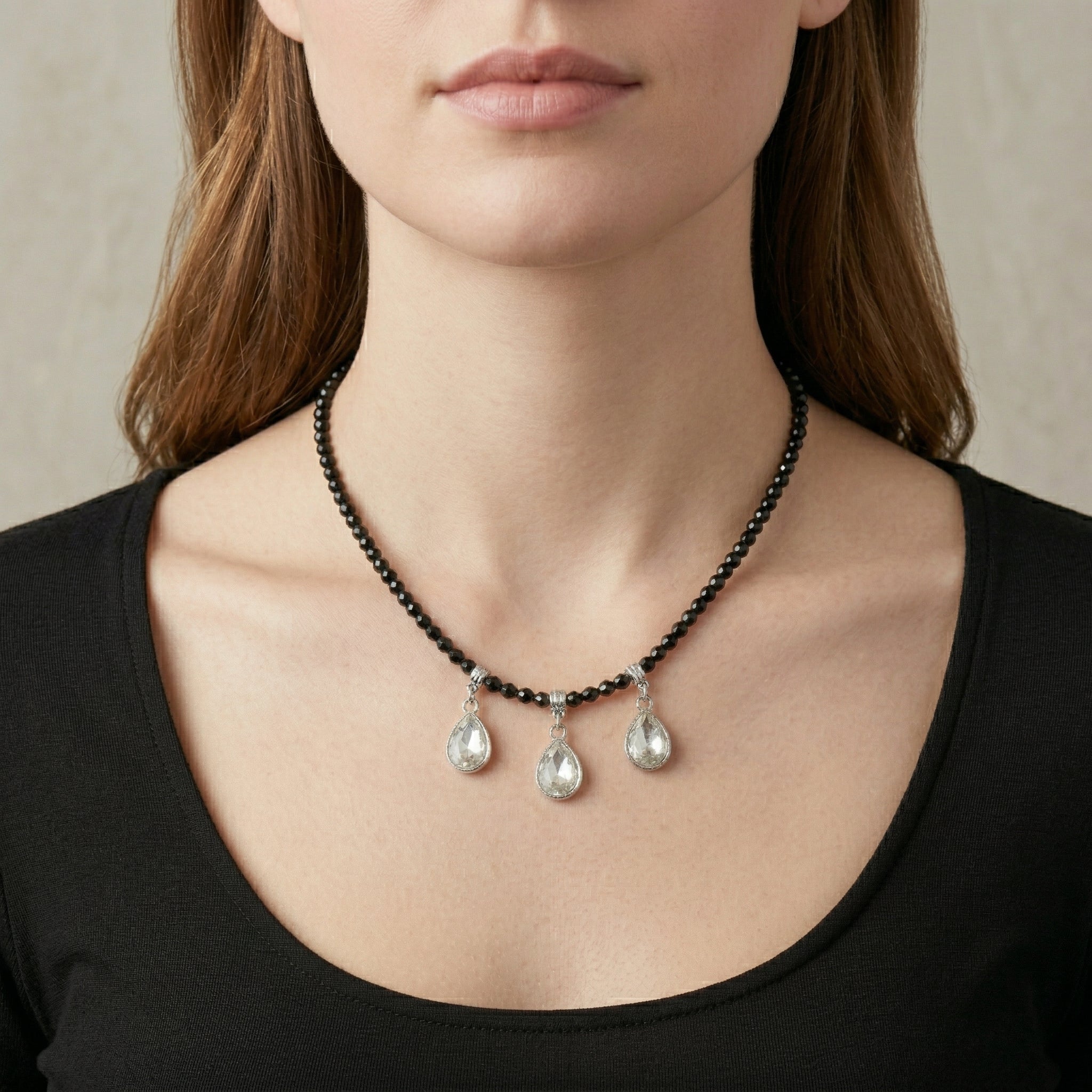 Woman in a black outfit wearing our Black Bead Small Crystal Teardrop Necklace 