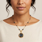 Woman in a white top wearing a Round Faceted Hematite Glass Stone Pendant Necklace