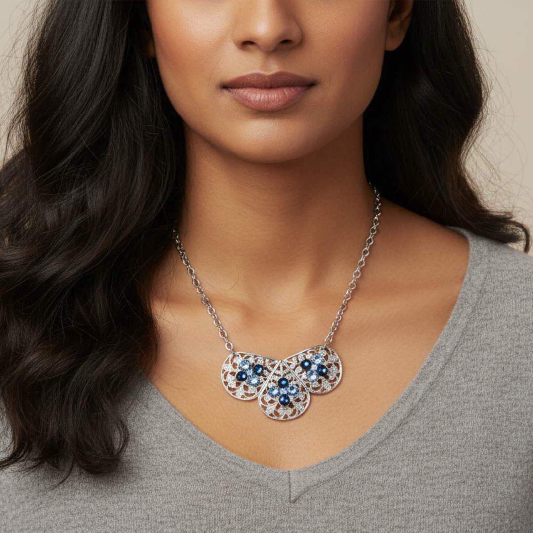 Woman wearing a silver necklace with blue stones on a neutral background