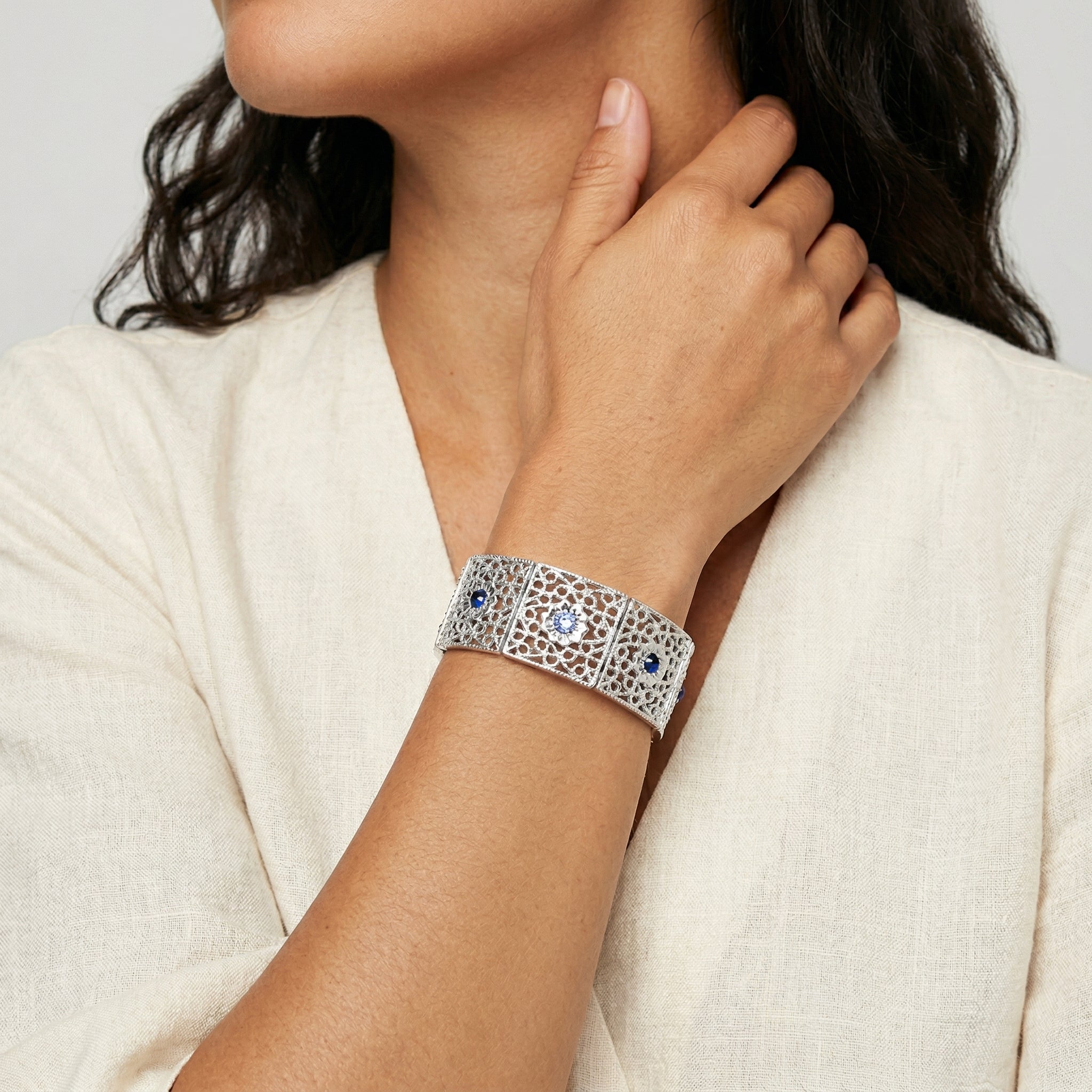 Woman in a white top wearing our Sapphire Blue Crystal Filigree Stretch Bracelet