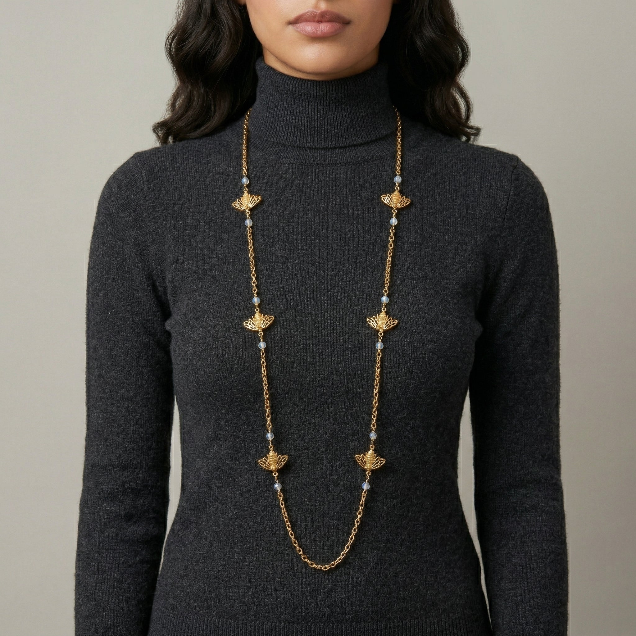 Woman in a dark turtleneck wearing our classic Quadruple Bee AB Crystals Chain Necklace