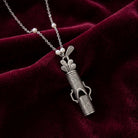 Golf Club Set Whistle Pendant Faux Pearl Necklace resting on dark red fabric