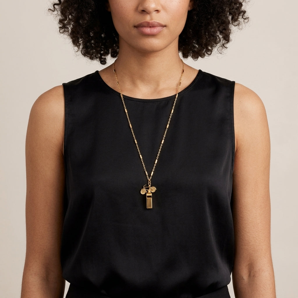Woman in a black outfit wearing a Vintage Bike & Functional Whistle Gold Tone Necklace 