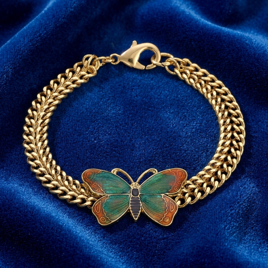 Gold tone bracelet with a multicolored butterfly design resting on dark blue fabric