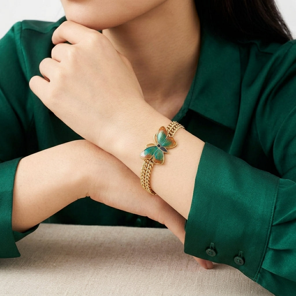 Woman wearing a gold tone chain bracelet with a beautiful butterfly design