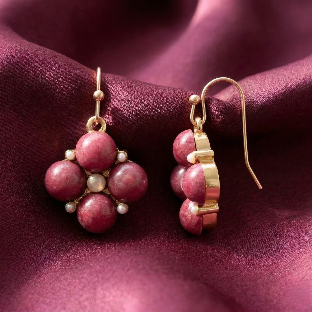 Howlite stone earrings with faux pearl accents on a pink satin fabric